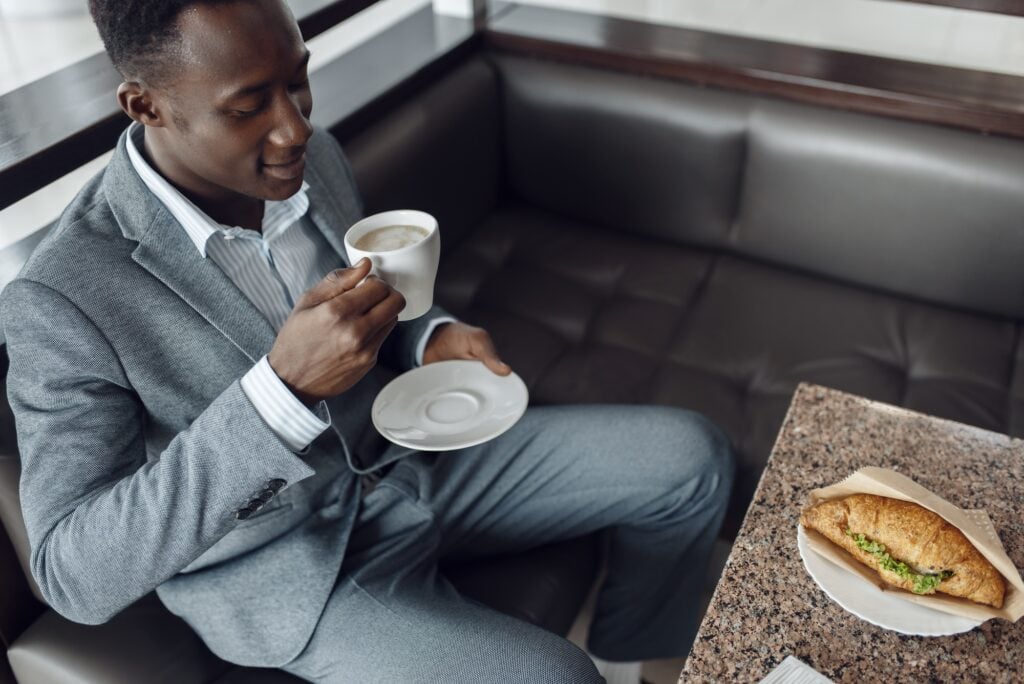 Black businessman having lunch in office cafe