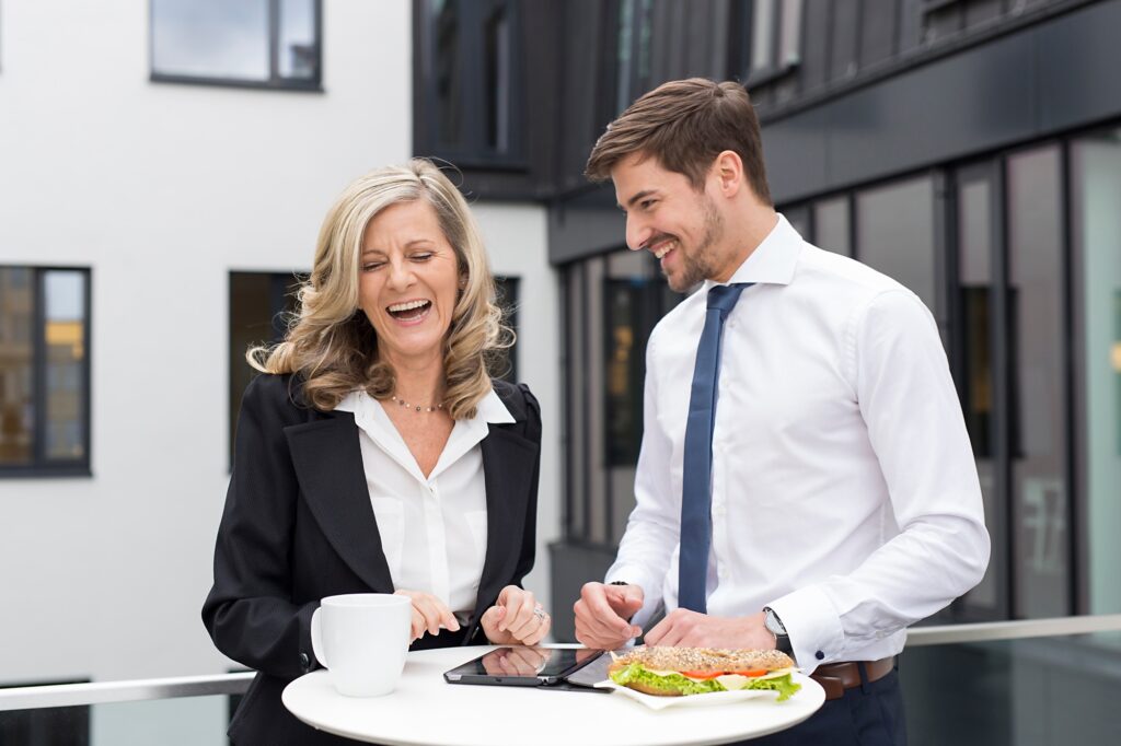 Laughing businessman and businesswoman having lunch break